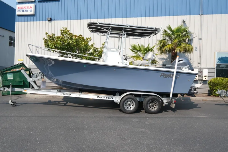 Slide: The Image of 2024 Parker 2100 Center Console boat on trailer outside Honda Marine building. - 2