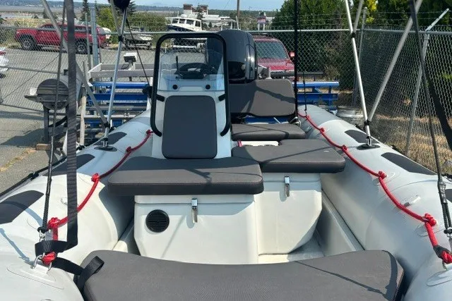 Slide: The Image of 2024 Zodiac Open 4.8 inflatable boat with seating, docked outdoors. - 6