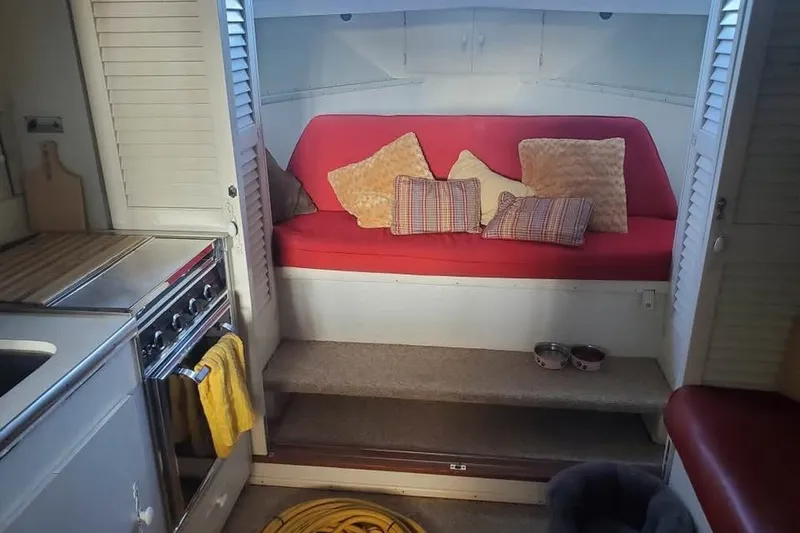 Slide: The Image of 1971 Chris-Craft 38 Commander interior with red seating, pillows, and kitchen area. - 7