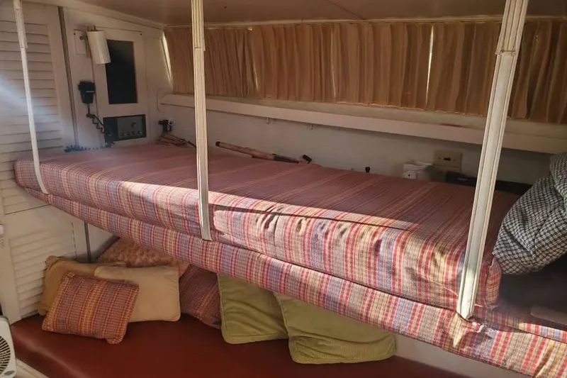 Slide: The Image of 1971 Chris-Craft 38 Commander interior with striped bedding and cozy cushions. - 13