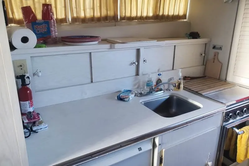 Slide: The Image of 1971 Chris-Craft 38 Commander kitchen with sink, stove, and storage cabinets. - 8