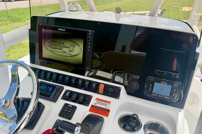 Slide: The Image of 2017 Sea Hunt BX25BR boat dashboard with steering wheel, controls, and navigation display. - 12