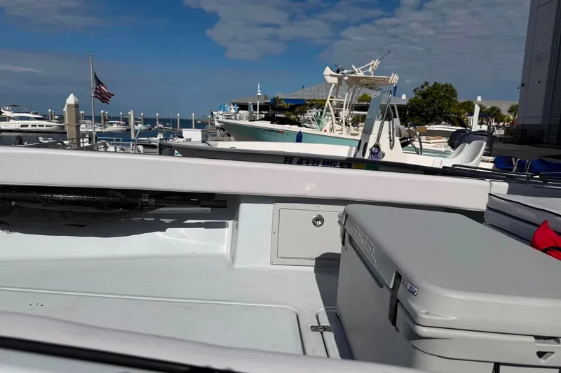 Slide: The Image of 2026 Custom West End Boat Works 25 docked at marina, clear sky, American flag visible. - 17