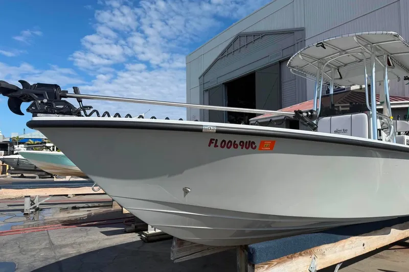 Slide: The Image of Custom West End Boat Works 25, 2026 model, docked near a warehouse under a blue sky. - 23