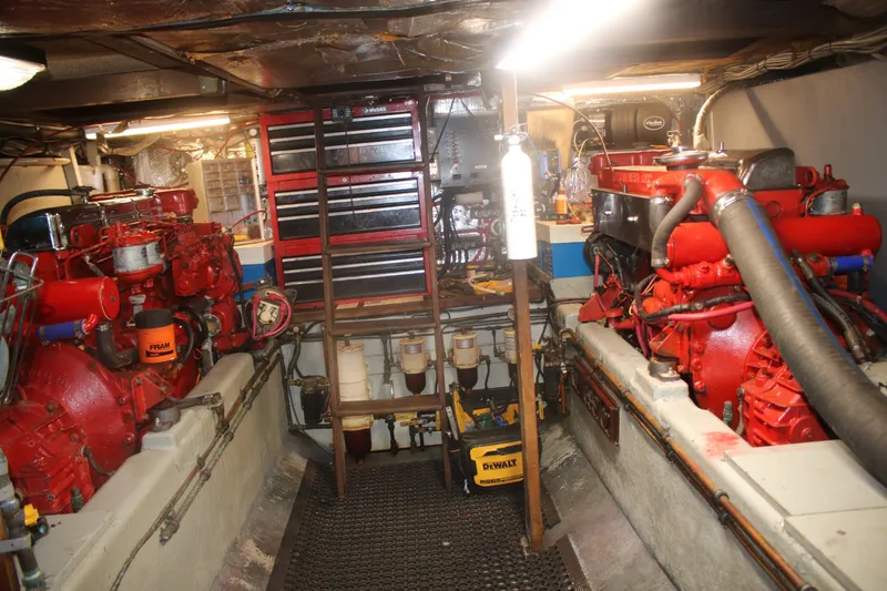 Slide: The Image of Engine room of 1981 Marine Trader 48 Trawler with red engines and tool storage. - 43