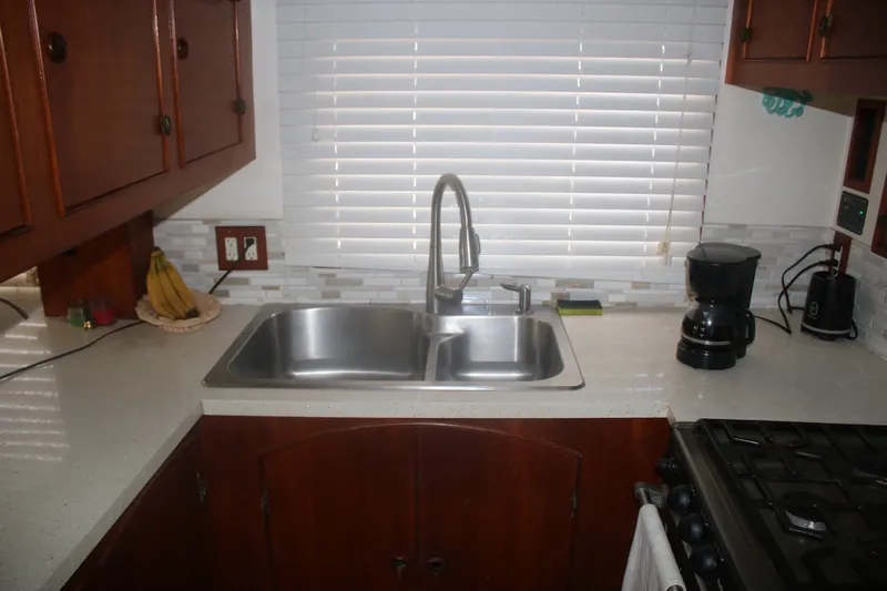 Slide: The Image of 1981 Marine Trader 48 Trawler kitchen with sink, coffee maker, and wooden cabinets. - 33
