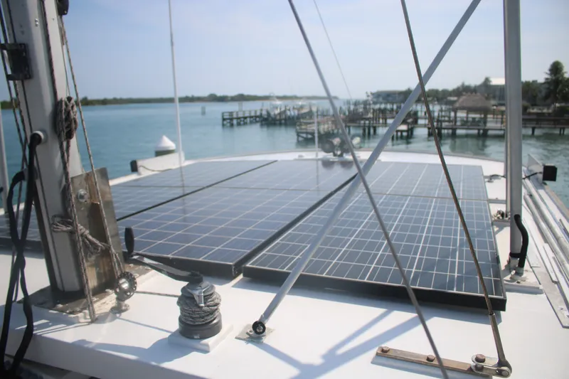 Slide: The Image of 1981 Marine Trader 48 Trawler with solar panels on deck, docked by the water. - 48