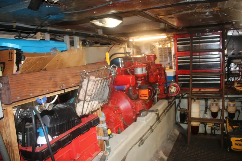 Slide: The Image of Engine room of a 1981 Marine Trader 48 Trawler with red machinery and tool storage. - 42
