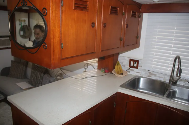 Slide: The Image of 1981 Marine Trader 48 Trawler kitchen with wooden cabinets, countertop, and sink. - 34
