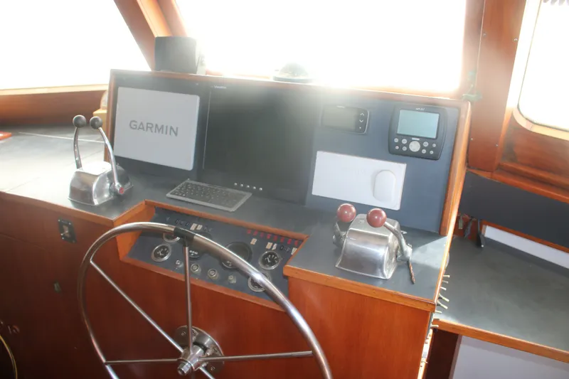 Slide: The Image of 1981 Marine Trader 48 Trawler helm with Garmin navigation system and classic wooden finish. - 23