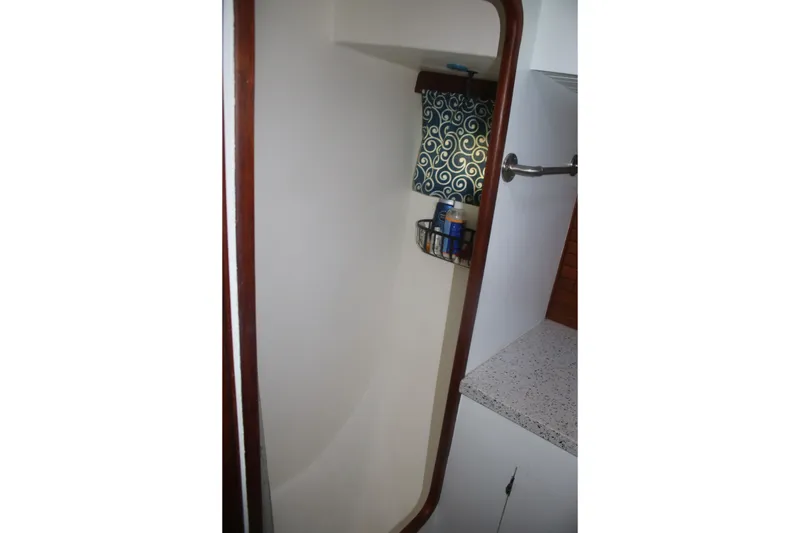 Slide: The Image of Interior of 1981 Marine Trader 48 Trawler, featuring a compact bathroom with storage shelf. - 28