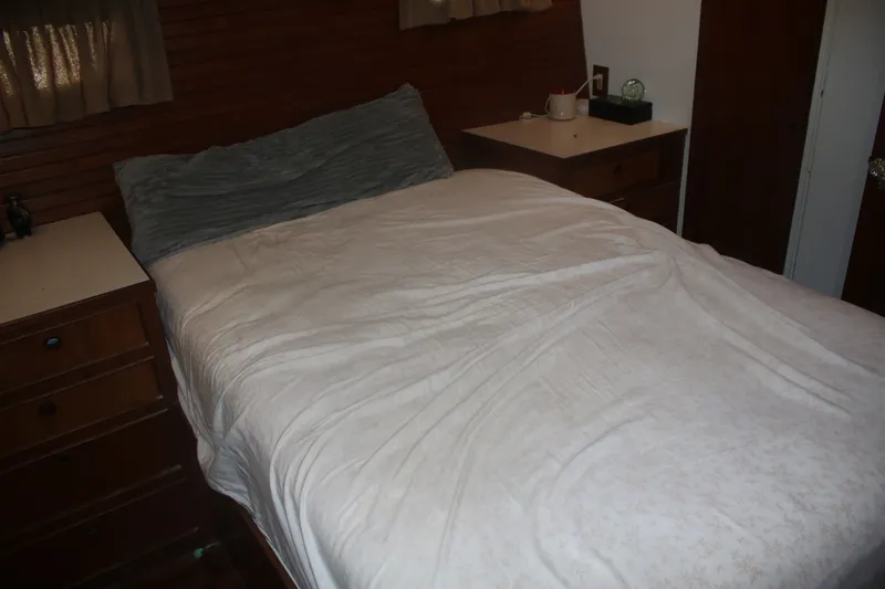 Slide: The Image of Cozy bedroom interior on 1981 Marine Trader 48 Trawler with wooden accents and soft bedding. - 30