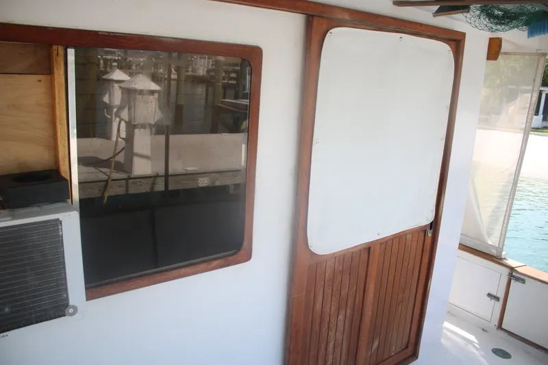 Slide: The Image of 1981 Marine Trader 48 Trawler interior with wooden door and window, dockside view. - 50