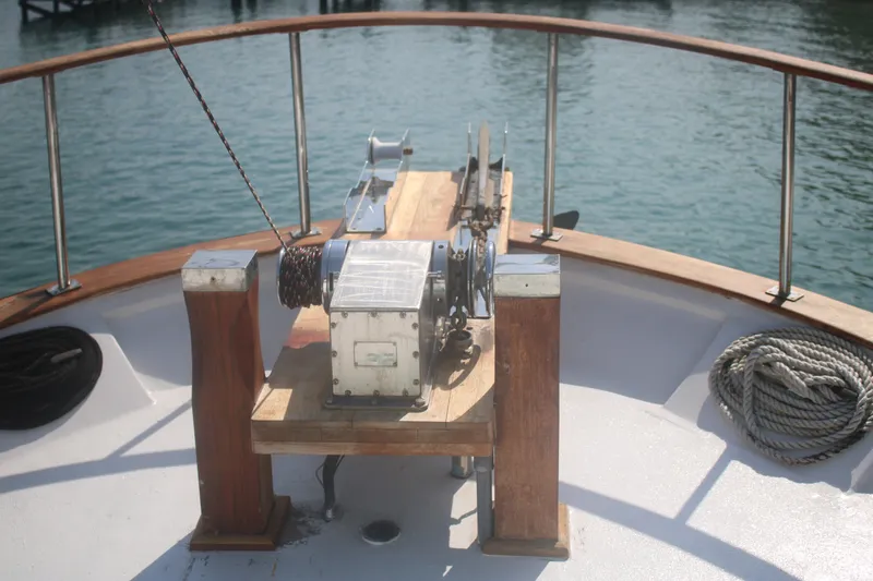 Slide: The Image of 1981 Marine Trader 48 Trawler deck with winch and ropes, overlooking calm water. - 20