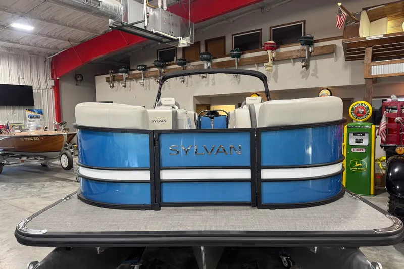 Slide: The Image of 2026 Sylvan X5 CLZ pontoon boat in showroom, featuring blue and white design. - 4