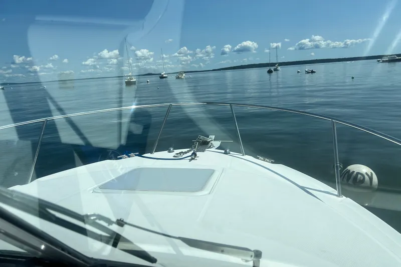 Slide: The Image of 2005 Wellcraft 252 Coastal boat on calm water with clear skies and distant boats. - 29