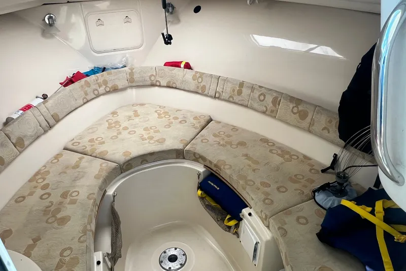 Slide: The Image of 2005 Wellcraft 252 Coastal cabin interior with cushioned seating and storage compartments. - 27