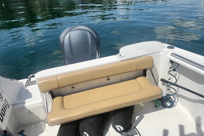 Slide: The Image of 2005 Wellcraft 252 Coastal boat with tan seating and outboard motor on calm water. - 26