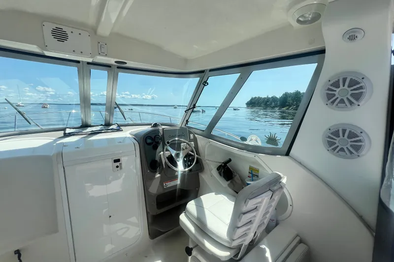 Slide: The Image of Interior view of 2005 Wellcraft 252 Coastal boat cockpit with steering wheel and scenic water view. - 14