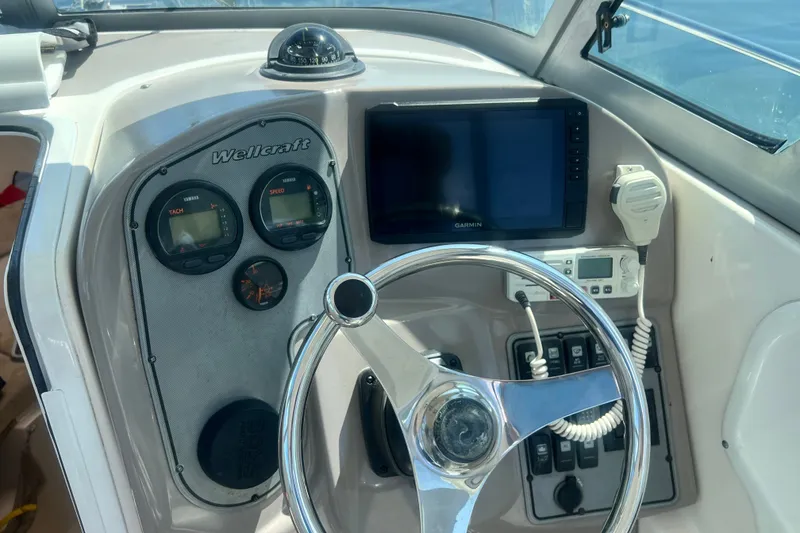 Slide: The Image of 2005 Wellcraft 252 Coastal boat dashboard with steering wheel, gauges, and Garmin display. - 21