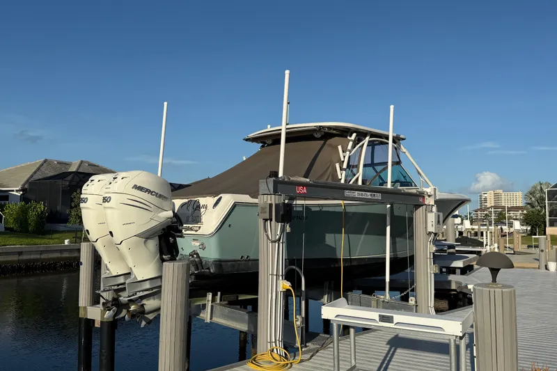 Slide: The Image of 2017 Sailfish 325 DC boat docked with twin Mercury engines, under clear blue sky. - 10