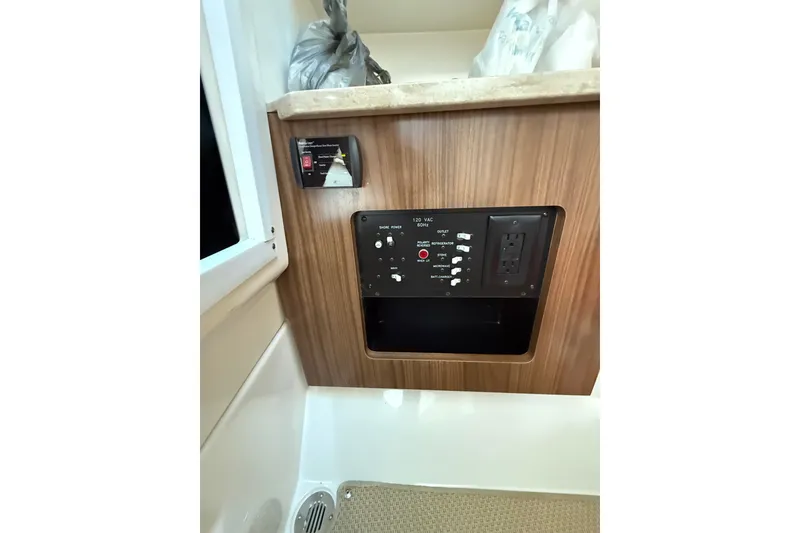 Slide: The Image of Control panel on 2017 Sailfish 325 DC boat with wood finish and electrical outlets. - 6