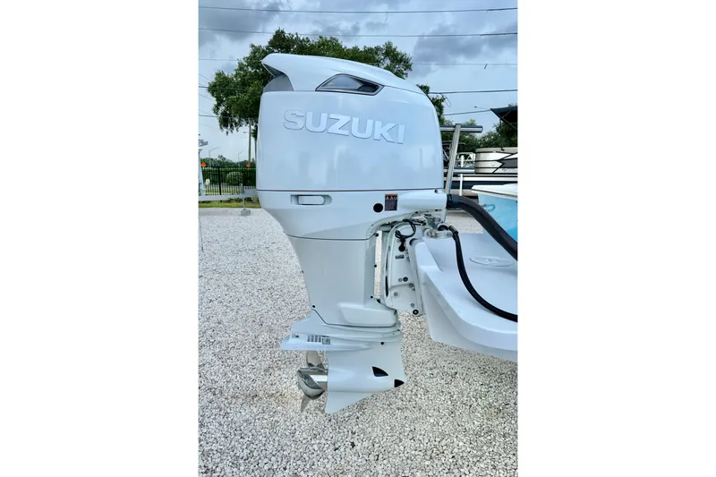 Slide: The Image of Outboard motor on a 2027 C-Hawk 25 Center Console boat, parked on gravel. - 33