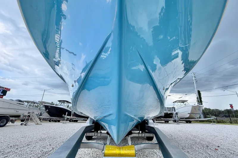 Slide: The Image of 2027 C-Hawk 25 Center Console boat on trailer, showcasing sleek blue hull design. - 32