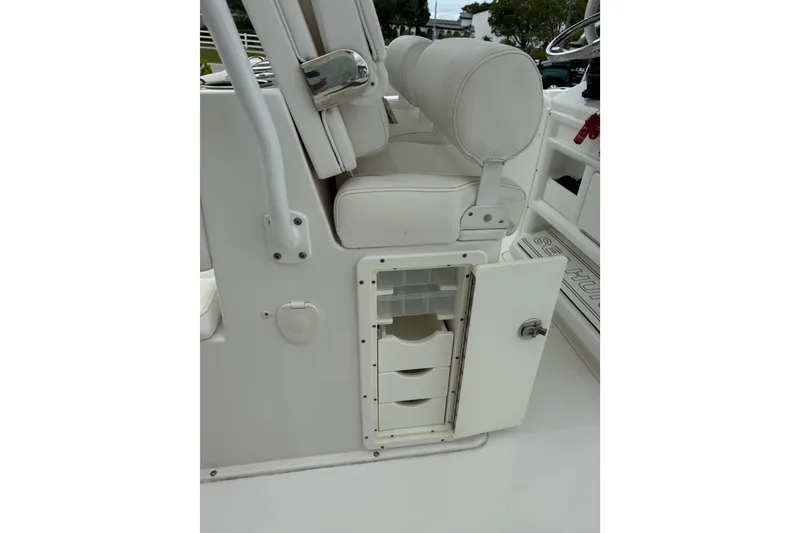 Slide: The Image of 2018 Sea Hunt Gamefish 27 boat interior with open storage compartment and white seating. - 16