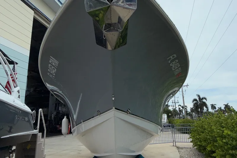 Slide: The Image of 2018 Sea Hunt Gamefish 27 boat docked, viewed from the front, with palm trees in background. - 20