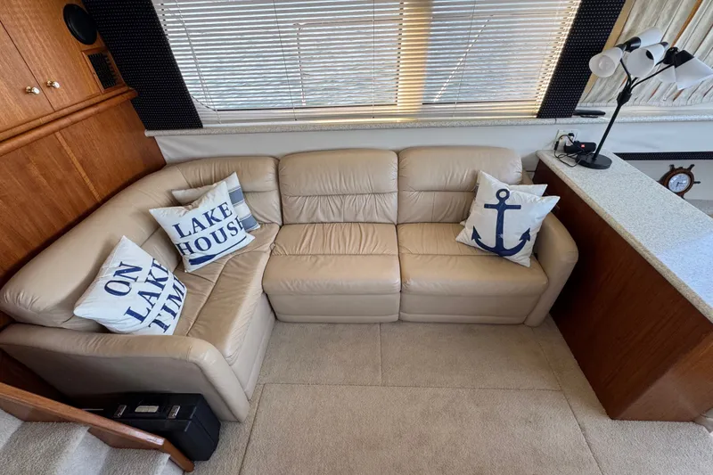 Slide: The Image of Luxurious interior of 2000 Carver 406 Aft Cabin Motor Yacht with beige leather sofa and nautical pillows. - 20