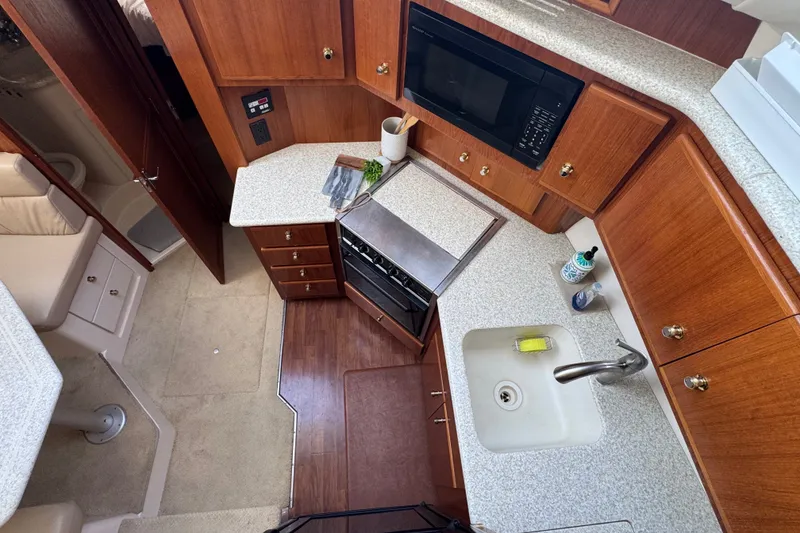 Slide: The Image of Interior of 2000 Carver 406 Aft Cabin Motor Yacht kitchen with wood cabinetry and appliances. - 22