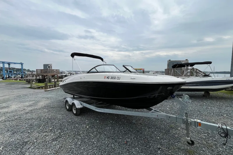 Slide: The Image of 2023 Bayliner VR6 Bowrider I/O on trailer at marina, overcast sky. - 1