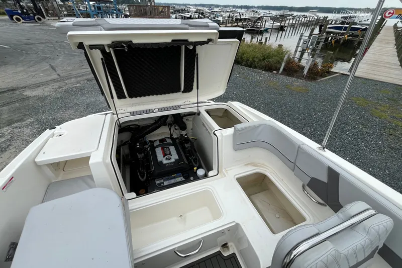 Slide: The Image of 2023 Bayliner VR6 Bowrider I/O boat with open engine compartment at marina. - 6