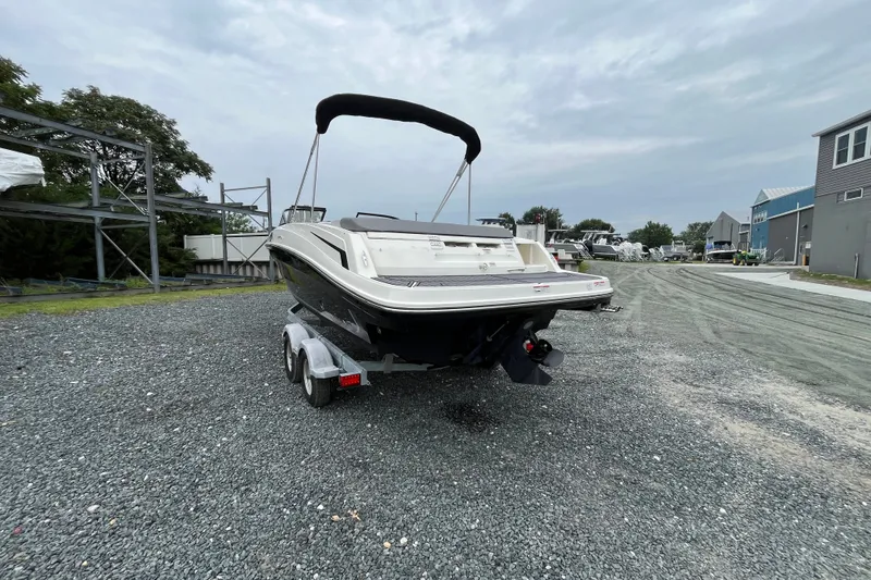 Slide: The Image of 2023 Bayliner VR6 Bowrider I/O on trailer, parked outdoors on gravel. - 2