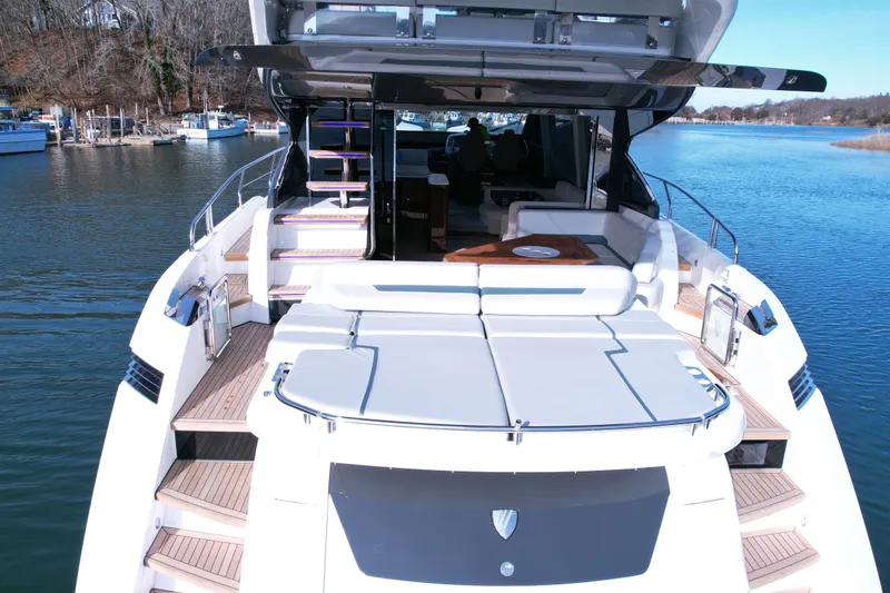 Slide: The Image of 2024 Fairline Phantom 65 yacht with spacious deck and luxurious seating on calm waters. - 4