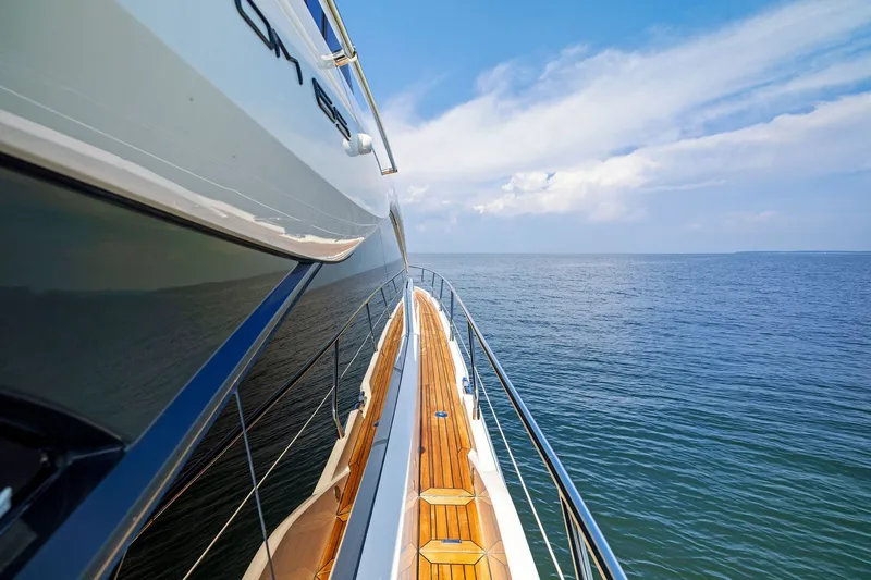 Slide: The Image of 2024 Fairline Phantom 65 yacht cruising on open sea under clear blue sky. - 72