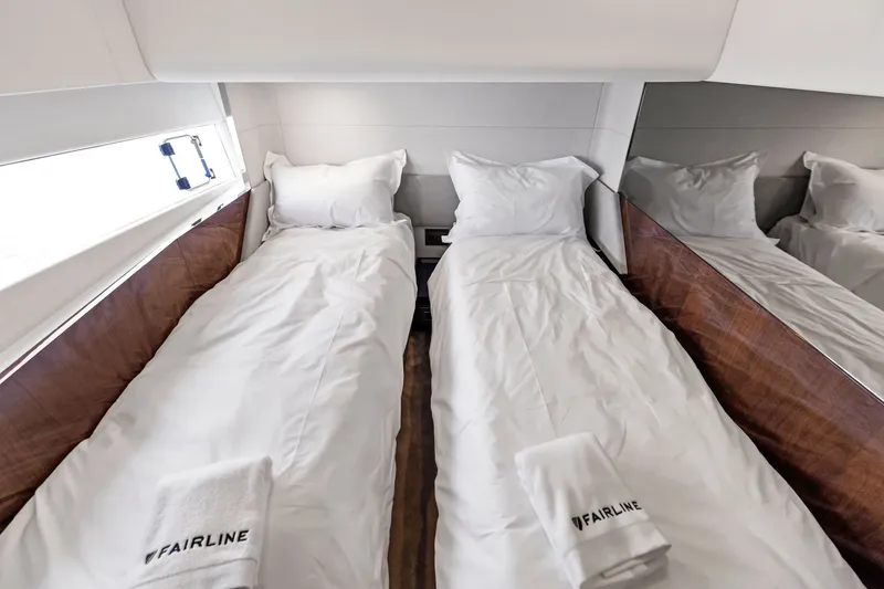 Slide: The Image of Twin beds in the 2024 Fairline Phantom 65 yacht cabin with white linens. - 44