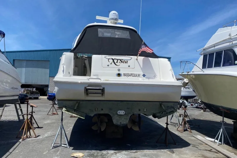 Slide: The Image of 2007 Sea Ray 40 Sundancer yacht on stands, rear view, in a boatyard under clear blue sky. - 20