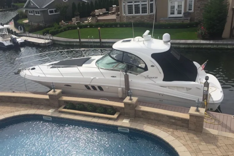 Slide: The Image of 2007 Sea Ray 40 Sundancer yacht docked by a luxurious waterfront property. - 2