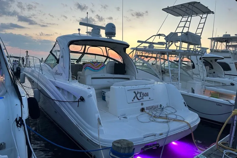 Slide: The Image of 2007 Sea Ray 40 Sundancer yacht docked at sunset with vibrant underwater lights. - 1