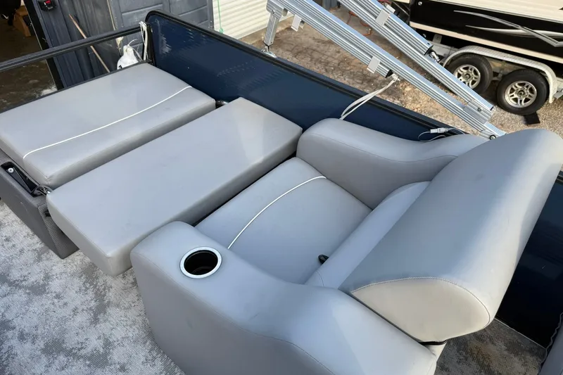 Slide: The Image of 2022 Crest 240 Classic CPTD boat interior with gray seating and cup holder. - 10