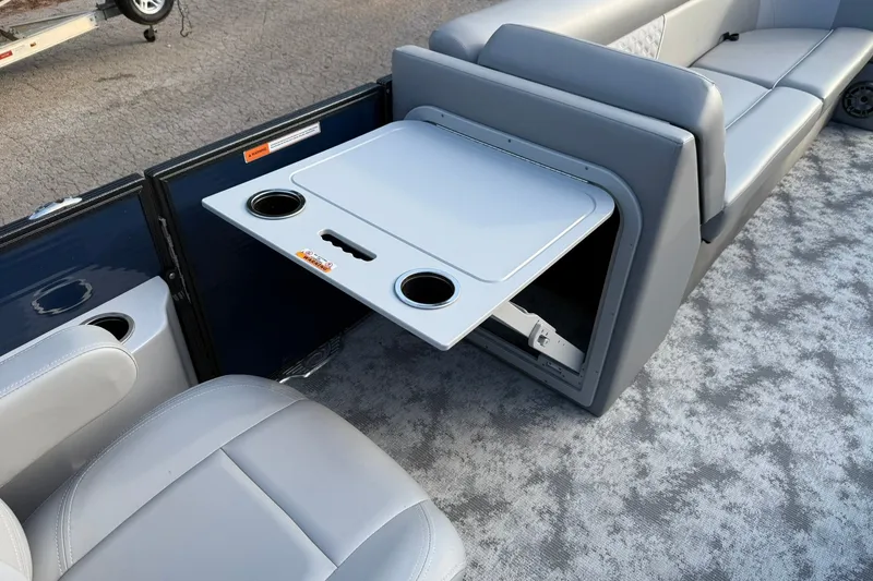 Slide: The Image of 2022 Crest 240 Classic CPTD boat interior with foldable table and cup holders. - 15