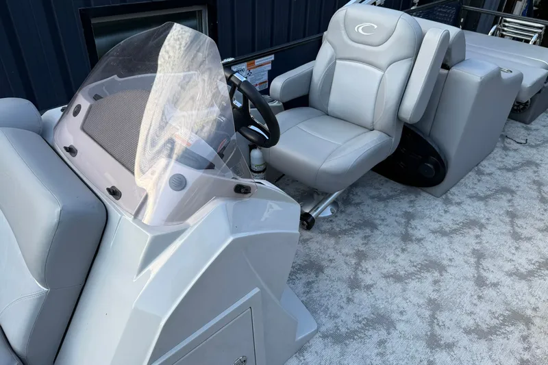 Slide: The Image of 2022 Crest 240 Classic CPTD boat interior with steering console and plush seating. - 7