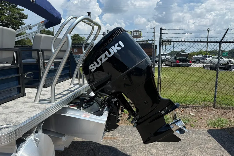 Slide: The Image of 2022 Crest 240 Classic CPTD pontoon boat with Suzuki outboard motor, parked outdoors. - 4