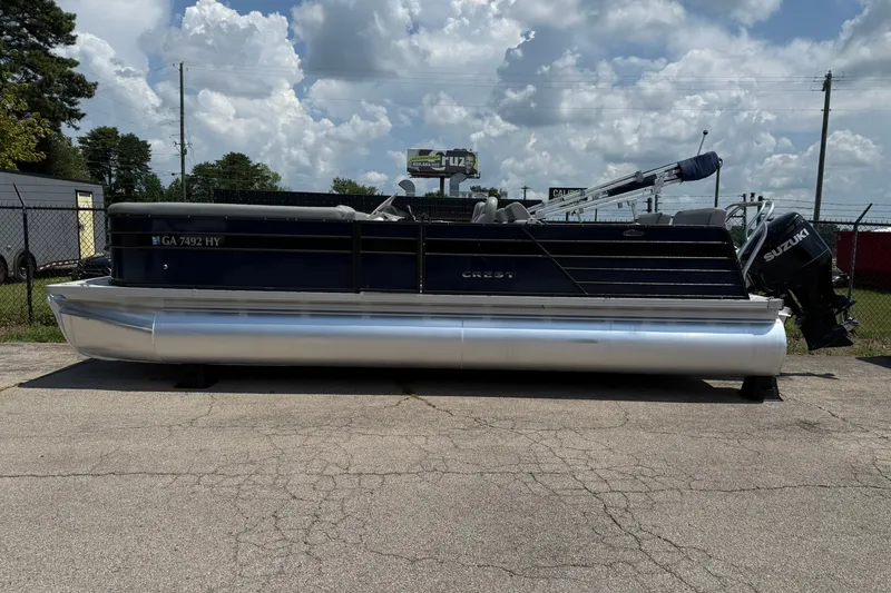 Slide: The Image of 2022 Crest 240 Classic CPTD pontoon boat with Suzuki outboard motor, parked outdoors. - 3