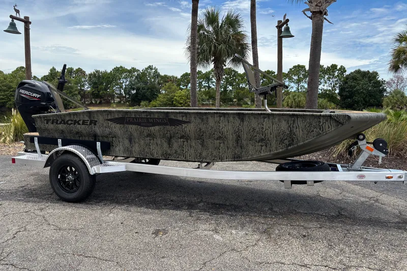 The Image of 2026 Tracker Grizzly 1650 T Prairie Wings Edition boat on trailer, outdoors with trees. - 0