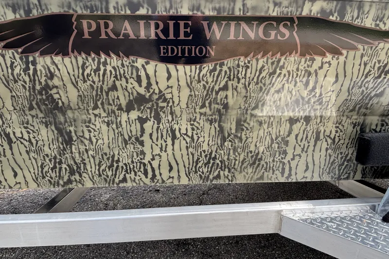 Slide: The Image of 2026 Tracker Grizzly 1650 T Prairie Wings Edition with camouflage design and logo. - 13