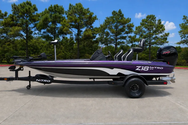 The Image of 2027 Nitro Z18 XL Pro boat on trailer, parked outdoors with trees in background. - 0