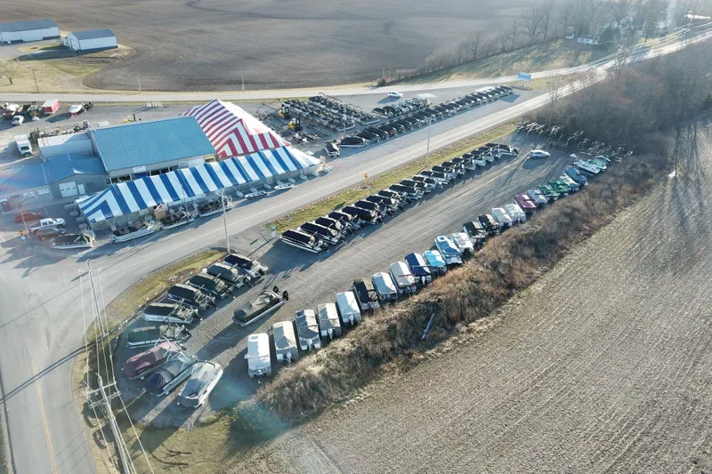 Slide: The Image of Aerial view of Barletta SANZA 22QC boats at dealership, 2027 model, with striped tents. - 10
